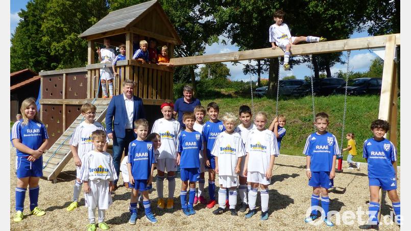 Junge Fußballspieler nehmen den neuen Spielplatz auf dem Gelände des TuS Kastl gleich in Beschlag. Bürgermeister Stefan Braun (links) und Vorsitzender Norbert Bleisteiner (rechts) haben die Anlage vorher eröffnet. Bild: jp