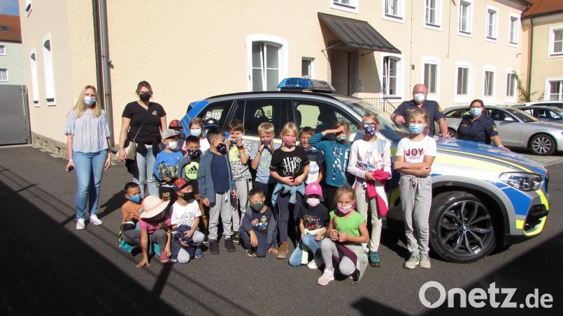 Die Hortkinder mit (hinten, von links) den Betreuerinnen Nadine Braun und Caroline Schenk sowie (hinten, von rechts) Polizeihauptmeister Christian Lenz und Polizeihauptmeisterin Diana Lenz. Bild: Kinderhaus Tausendfüßler/exb