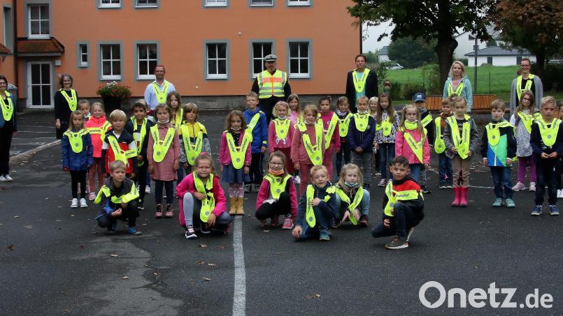 Als erstes im Landkreis erhielten die Erstklässler der Grundschule Wiesau die reflektierenden Überwürfe. Rektorin Inge Dick (links) und stellvertretende Schulamtsleiterin Martina Puff (Zweite von links) zeigten sich vom Projekt „Sicherheit durch Sichtbarkeit“ überzeugt. Mit im Bild: Lehrerin Johanna Schmid, Lehrerin Melanie Dehen, Polizeihauptkommissar Wolfgang Trottmann, Jürgen Jaspers (Verkehrswacht) und Wolfgang Lindner (AOK) und die Kinder der Klassen 1a und 1b. Bild: wro