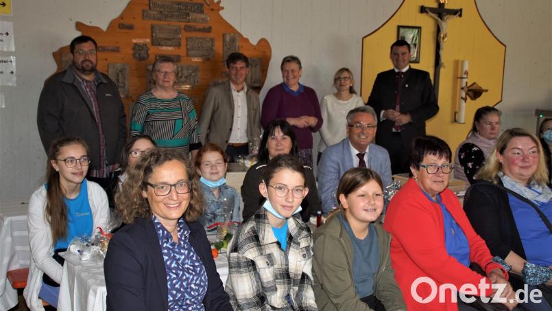 Kinder, Frauen des Klöppelkreises und Ehrengäste bei der Vorstellung des Märchenbaums in der Aula der Schule. Bild: mmj