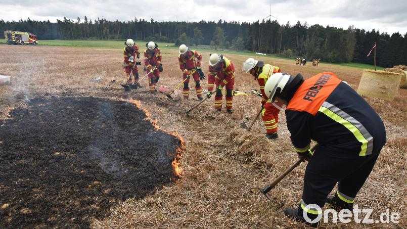 Einsatzkräfte der Feuerwehr Illschwang sorgen mit Spezialwerkzeug für eine Einengung des Brandherdes auf dem Stoppelfeld bei Illschwang. Bild: no
