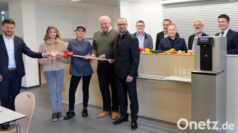 Aus den Händen von Architekt Konrad Kraus und E-Technikplaner Norbert Hiller erhalten die Leiterin der Küche, Christina Seehaus, Schülerin Franziska Wild und Bürgermeister Peter Neumeier (von links) symbolisch den Kochlöffel für den Start der neuen Mensa. Im Hintergrund Mitarbeiter von Johanniter und Schulleitung. Bild: mab