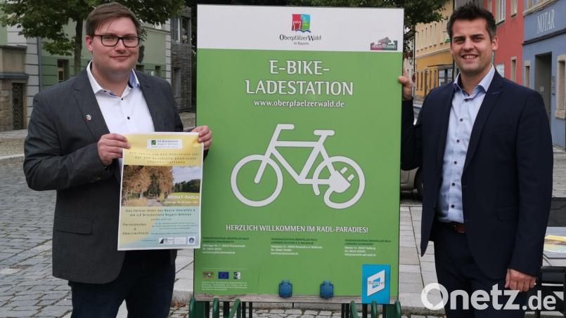 Der ILE-Vorsitzende, Bürgermeister Rudolf Teplitzky, präsentiert zusammen mit dem ILE-Manager Christian Karl das Programm für das „Heimat-Radeln“. Eine Station wird am Marktplatz in Oberviechtach gleich hinter der E-Bike-Ladestation sein. Bild: Portner
