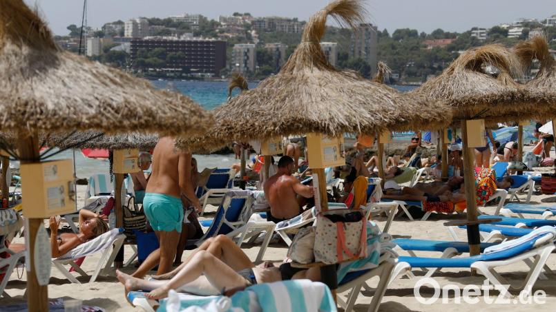 Einheimische und Touristen liegen am Strand Cala Major in Palma de Mallorca. Darauf müssen Touristen beim Herbsturlaub in der Pandemie achten. Symbolbild: Clara Margais/dpa