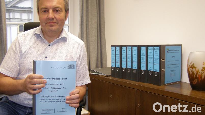 Verwaltungs-Geschäftsführer Martin Rosner in seinem Büro im Rathaus Waldsassen mit dem Planfeststellungsbeschluss. Rechts auf dem Schrank die acht Ordner mit den Planunterlagen. Bild: pz