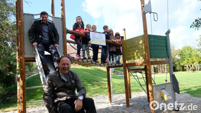 Nicht nur die Kinder freuten sich über das neue Klettergerüst: Bürgermeister Peter Neumeier und Geschäftsführer Renè Guhl (von links) probierten die Rutsche gleich aus. Bild: mab
