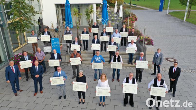 Die 26 &quot;Goldenen Handwerksmeister&quot; mit Gerhard Ulm, Vizepräsident der Handwerkskammer Niederbayern-Oberpfalz, und Bürgermeister Martin Preuß (vorne von links). Bild: gsp