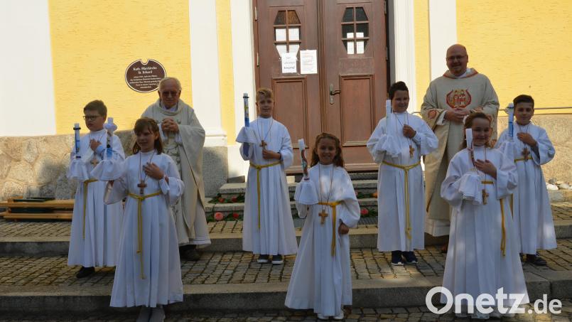 Pfarrer Gerhard Schmidt (links) und der Weidener Dekan Johannes Lukas (rechts), ein Onkel eines Kommunionkindes, feierten mit den sieben Kindern in der Pfarrkirche St. Erhard Erstkommunion. Bild: doj