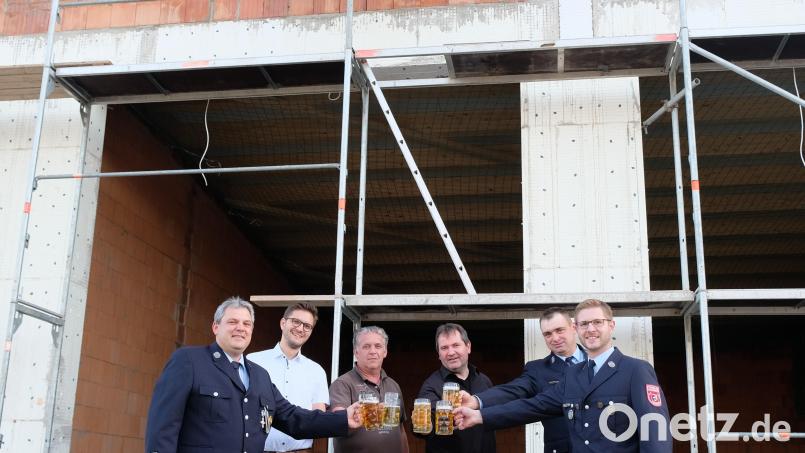 Bier statt Sekt: Stellvertretender Kommandant Stefan Lautner (von rechts), Bauleiter Matthias Stelzl, Baumeister Richard Hösl, Bürgermeister Alexander Goller, zweiter Feuerwehrvorstand Matthias Schickentanz und Kommandant Tobias Lautner stoßen unter dem weiß-blauen-Richtfest-Bäumchen an. Bild: do