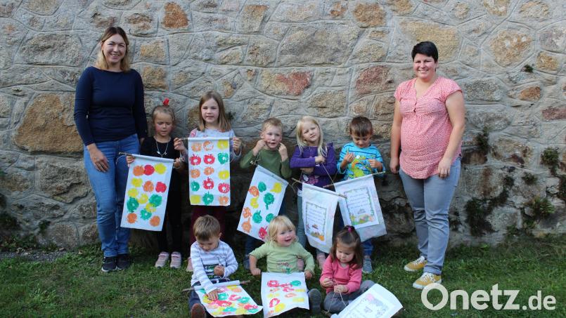 Stolz präsentierten die Kinder ihre Wimpel zum Thema Erntedank. Magdalena Niebauer (links) und Christina Mühlbauer (rechts) kümmerten sich um die kleinen Bastler. Bild: mnt