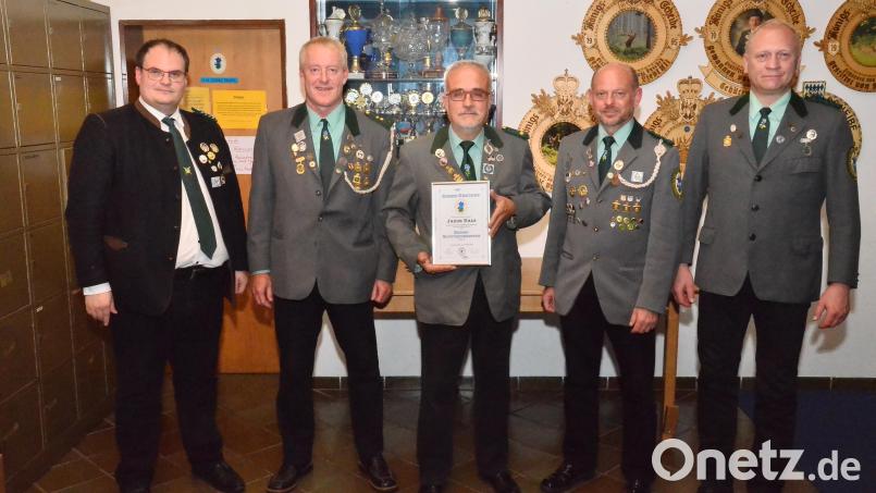 Gauschützenmeister Stefan Brandmiller (links) überrascht Jakob Kals (Mitte) mit der bayerischen Verdienstnadel, während ihn der eigene Schützenverein in den Stand des Ehrenschützenmeisters hebt. Bild: fjo