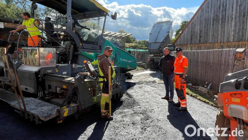 Komplett neu geteert ist die Pfarrer-Bock-Gasse (150 Meter) in Michldorf. Bürgermeister AntonKappl (Zweiter von rechts) erklärt, dass die Gemeinde an 30 Stellen arbeiten ließ. Bild: fz