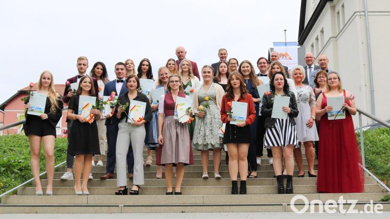 Stolz präsentieren die Absolventen (im Bild mit den Ehrengästen) ihre Zeugnisse. Der Notendurchschnitt: 2,0. Bild: Klinikum Fichtelgebirge/exb