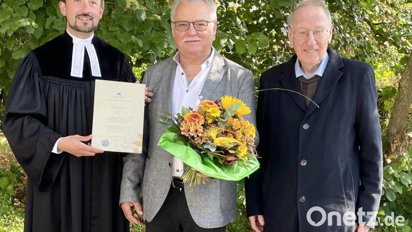 Die Pfarrer Stefan Fischer (links) und Pfarrer Klaus Plorin (rechts) ehrten den langjährigen Lektor Manfred Hellbach. Bild: wku