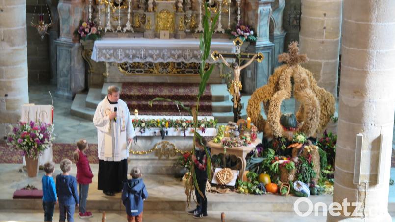 Eine große Maispflanze hatten Kinder von Junglandwirten zur Erntedankandacht, die Pfarrer Thomas Kraus (links) zelebrierte, in die Stadtpfarrkirche mitgebracht. Bild: jzk