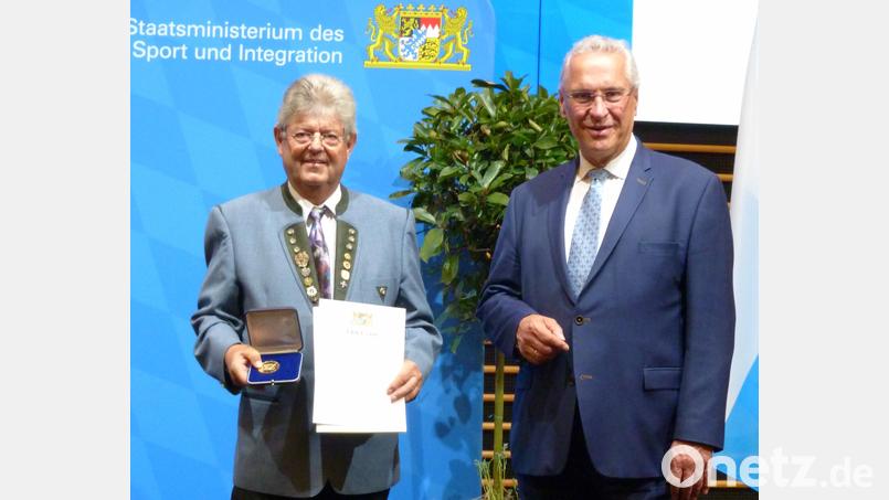 Innenminister Joachim Herrmann zeichnete den Sulzbach-Rosenberger Werner Fischer für seine besonderen Verdienste im Schützensport mit einer Ehrenmedaille und Urkunde des Freistaates Bayern aus. Bild: Fischer/exb