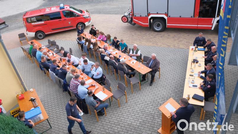 Um das Infektionsrisiko gering zu halten, nutzte die Feuerwehr Teunz das schöne Spätsommerwetter und hielt die Jahreshauptversammlung im Freien. Im Hintergrund ist der neue Mannschaftstransporter zu sehen. Bild: tkr