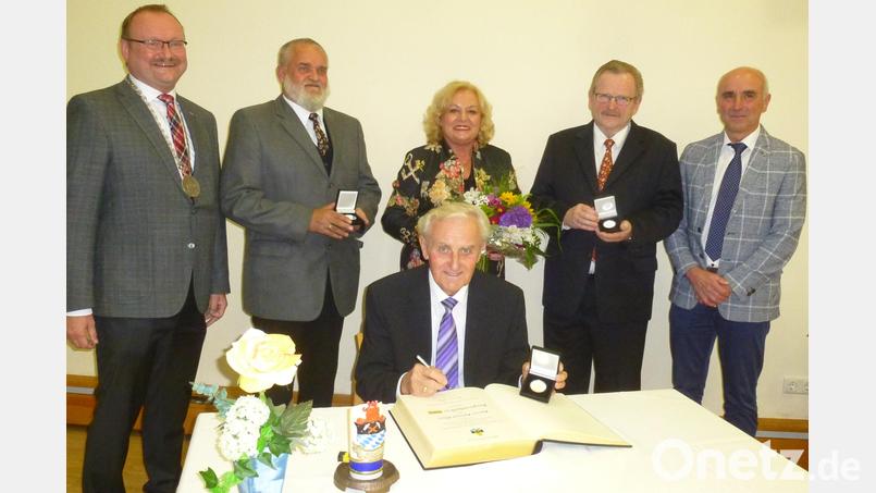Der Freihunger Bürgermeister Uwe König verleiht Bürgermedaillen in Silber an Harald Häusler, Irmgard Macke und Hermann Lühr (hinten, von links). Helmut Klier (sitzend) erhält die Goldene und trägt sich ins Goldene Buch der Marktgemeinde ein. Ihnen allen gratuliert Zweiter Bürgermeister Klaus Siegert (rechts). Bild: bk