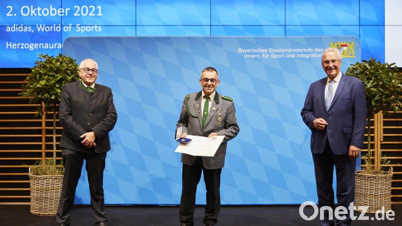 Stellvertretender Landesschützenmeister Dieter Vierlbeck (links) und Bayerns Innen- und Sportminister Joachim Herrmann (rechts) gratulieren Albert Riedl. Bild: Bayerisches Staatsministerium des Innern, für Sport und Integration/exb