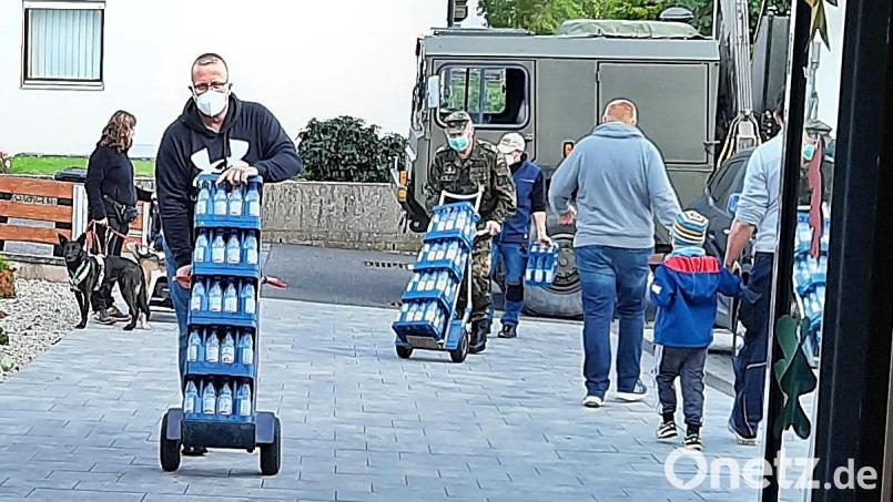 Die Helfer hatten alle Hände voll zu tun, um die 80 Wasserkisten in das Kinderhaus zu schaffen. Bild: zer