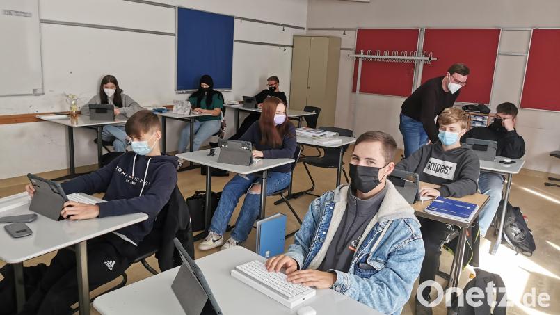 Die Schülerinnen und Schüler der Klasse 9aG der Wirtschaftsschule Weiden lösen ihre Aufgaben am iPad. Unterstützt werden sie von Deutschlehrer Peter Messbauer. Bild: tkr