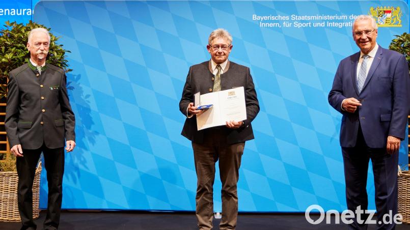 Hans Lindner (Mitte) erhielt von Staatsminister Joachim Herrmann (rechts) die Ehrenmedaille. Bild: Christine Blei/exb