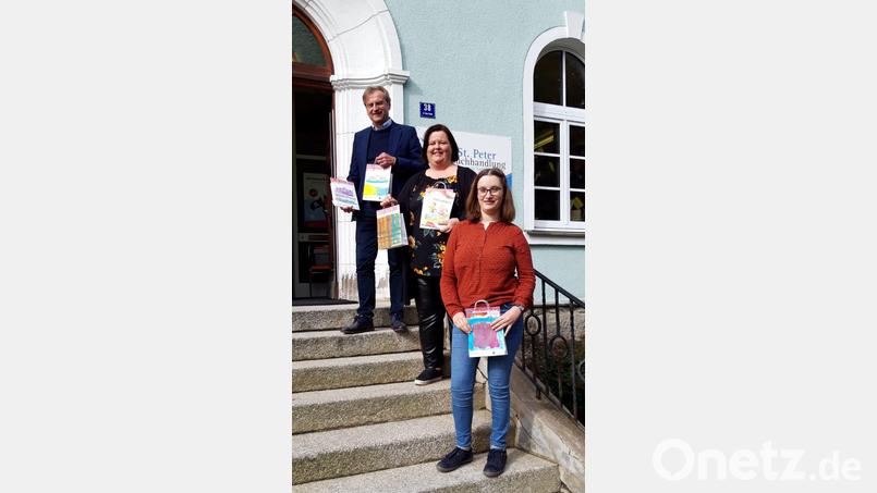 Die St. Peter Buchhandlung verschenkt Lesetüten an Schulanfänger. Im Bild: Geschäftsführer der Lebenshilfe Berthold Kellner (hinten), stellvertretende Leiterin der Buchhandlung Margot Konz (Mitte) und Mitarbeiterin Ina Döhler (vorn). Bild: St. Peter Buchhandlung/exb