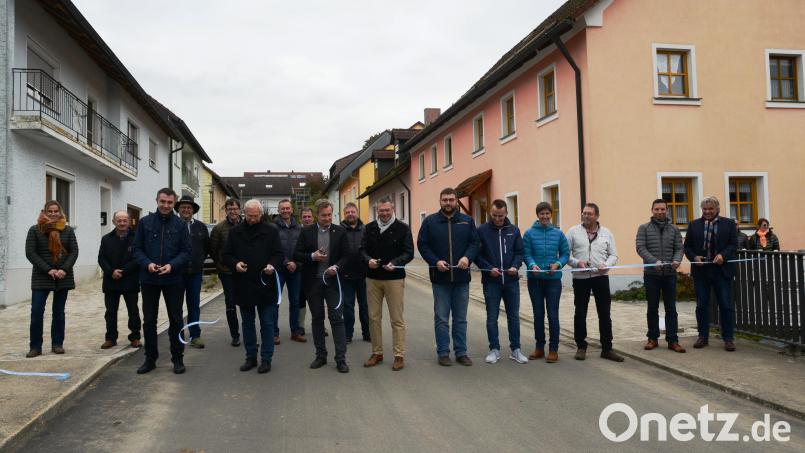 Mit dem Durchschneiden des blauen Bandes weihen Bürgemeister Reinhard Sollfrank, Architekt Markus Münchmeier und die Marktgemeinderäte die Ortsdurchfahrt Schwand offiziell ein. Bild: bey