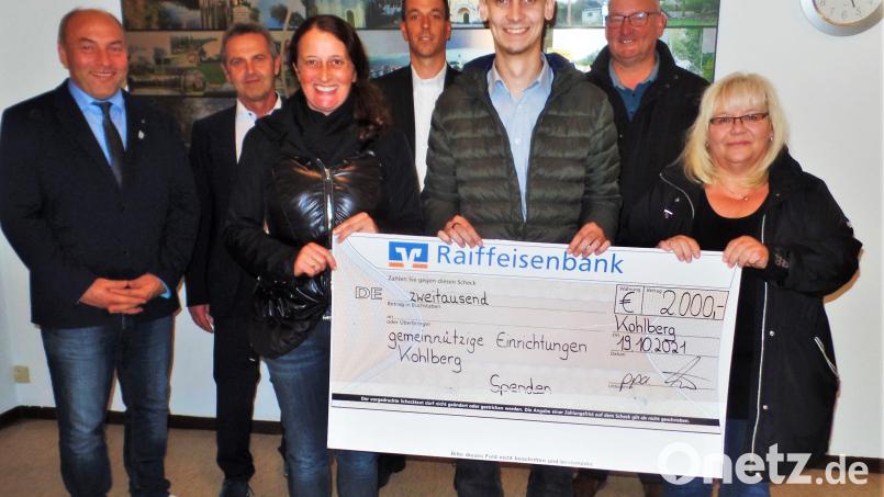 Spender und Empfänger mit der Bildcollage von „Marthe“. Den Scheck über 2000 Euro fest in der Hand halten (von links) Kindergartenleiterin Marion Eitel, Zweiter SV-Vorsitzender Michael Knöbl und Wilma Bäumler vom Büchereiteam. Bürgermeister Gerhard List freut sich über den Zuschuss zum Bild im Hintergrund. Prokurist Helmut Forster und Zweigstellenleiter Dominik Pritzl aus Weiherhammer überbrachten den Geldsegen, den Sportvereinschef Thomas Knöbl für die Arbeit mit jungen Kickern einsetzen wird (hinten, von links). Bild: jml