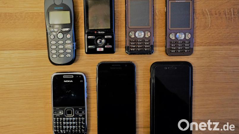 Einige der alten Handys und das aktuelleste Smartphone unseres Autors (obere Reihe, zweites Display von links). Ein paar Geräte haben es nicht mit aufs Bild geschafft - sie sind längst Elektroschrott. Bild: jut