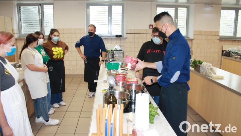 Pizza und Pasta mit den Profis gibt es an der Grund- und Mittelschule Grafenwöhr: Küchenmeister Adriano Colella (rechts) und Koch Nico Salzer (Mitte) zeigen den Achtklässlern die Zubereitung der italienischen Nationalgerichte. Über 100 Portionen bereiten die Schüler dann gemeinsam mit den beiden zu – sehr zur Freude von Mitschülern und Lehrern. Bild: edo