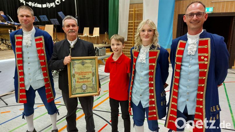 Vorsitzender Tobias Baumer (links) überreichte Alois Schneeberger die Ernennungsurkunde zum Ehrenstabführer. Rechts Thomas Gitter, der zusammen mit seinen Kindern Julia und Jonah Stationen des Geehrten sowie des gesamten Ensembles Revue passieren ließ. Bild: lg
