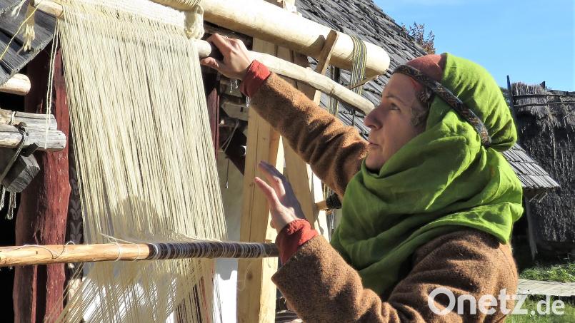 Wie ein Webstuhl damals funktionierte, zeigte diese Darstellerin. Sie hat das Handarbeitsgerät vor dem Langhaus aufgebaut. Bild: ubb