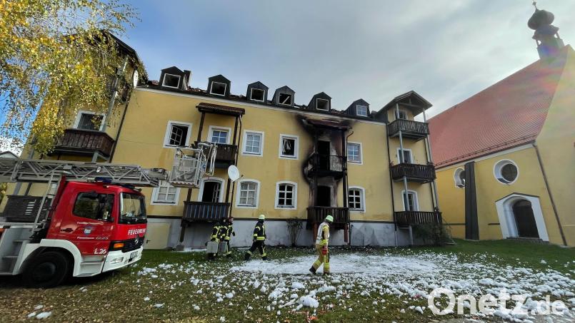 Feuerwehrleute stehen vor einem Haus in Reisbach im niederbayerischen Landkreis Dingolfing-Landau. Drei Frauen und ein frühgeborenes Baby sind hier bei einem Brand ums Leben gekommen. Bild: Armin Weigel/dpa