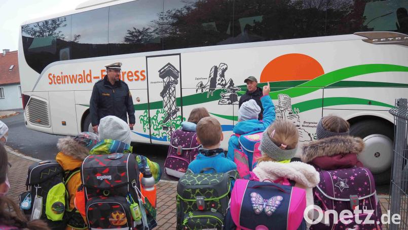 Polizeioberkommissar Carsten Landgraf (hinten links) und Busfahrer Bernhard Schultes (hinten rechts) beim Praxisunterricht &quot;Sicher Busfahren&quot;. Bild: njn