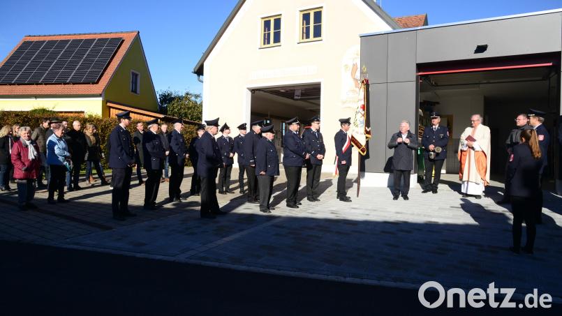 Architekt Josef Schöberl (Fünfter von rechts) beschreibt den Besuchern der Segnung der Erweiterung des Feuerwehrhauses Hammerles die Überlegungen für die Maßnahme. Bild: bey