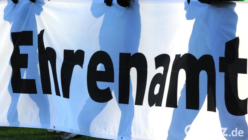 Jugendliche halten ein Banner mit der Aufschrift «Ehrenamt» in den Händen. Bild: Patrick Seeger/dpa