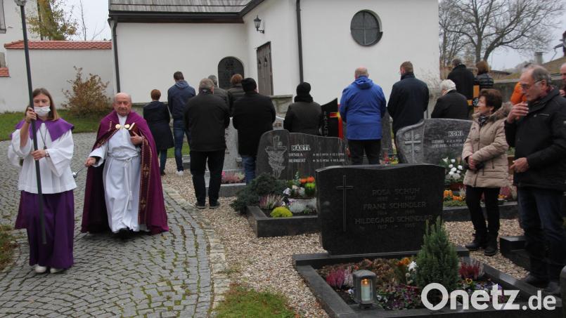 Pfarrer Konrad Gruber beim Segnen der Gräber. Bild: kro
