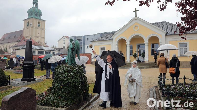 Allerheiligen auf dem Dreifaltigkeitsfriedhof in Amberg: Pfarrer Ludwig Gradl geht von Grab zu Grab. Bild: Wolfgang Steinbacher