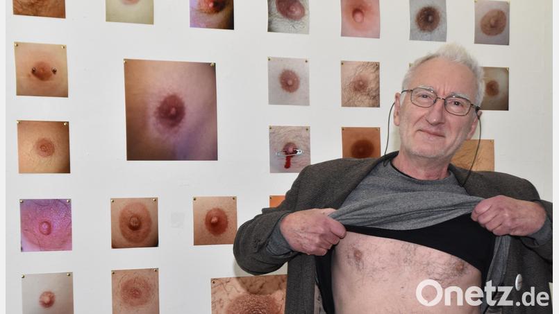 Kunstverein-Vorsitzender Wolfgang Herzer lüftet sein T-Shirt vor der &quot;Nippel- Wall&quot; und zeigt Brust. Bild: hcz