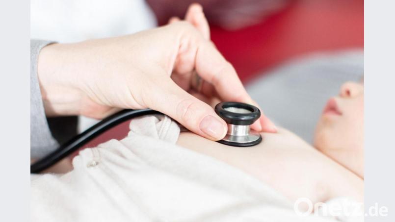 Ein Kind wird von einem Arzt mit einem Stethoskop abgehört. Symbolbild: Friso Gentsch/dpa