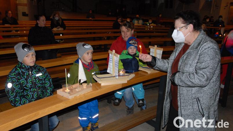 In der Pfarrkirche entzündet Mesnerin Claudia Kraus die Kerzen auf den Schiffchen der Kinder. Bild: pop