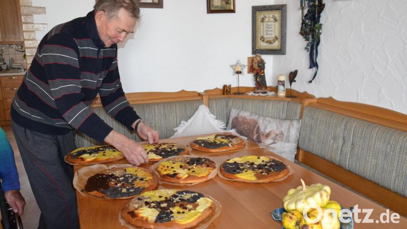 35 Kirwakuchen haben drei Familien in ihren kleinen hofeigenen Holzbackofen heraus gebacken. Hans Seiler schlichtet sie auf den Tisch auf. Bild: gi