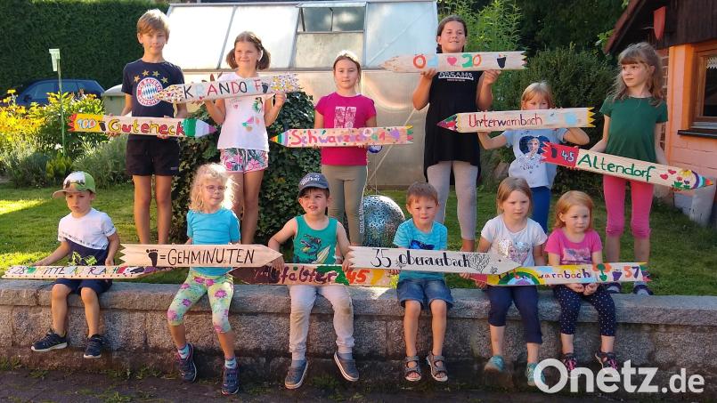 Stolz präsentieren die Kinder ihre selbst bemalten Hinweisschilder zu den jeweiligen Ortschaften. Bild: Georg Mayer/exb