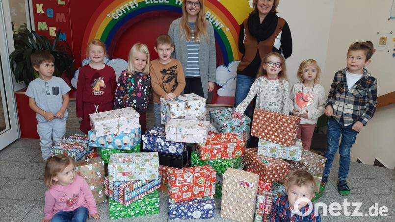 Einige der Kinder präsentieren mit Kita-Leiterin Tanja Ruckdäschel und Mitarbeiterin Christina Schinagl (von rechts) die Päckchen, die sie für ihre Altersgenossen vorbereitet haben. Bild: Evi Stahl/exb