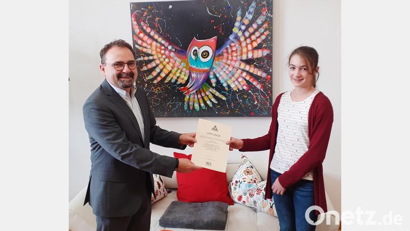 Annika Piller und Christian Weiß-Mayer, Direktor des Erasmus-Gymnasiums, mit einer Urkunde, die, wie er sagte, Seltenheitswert hat. Bild: ero