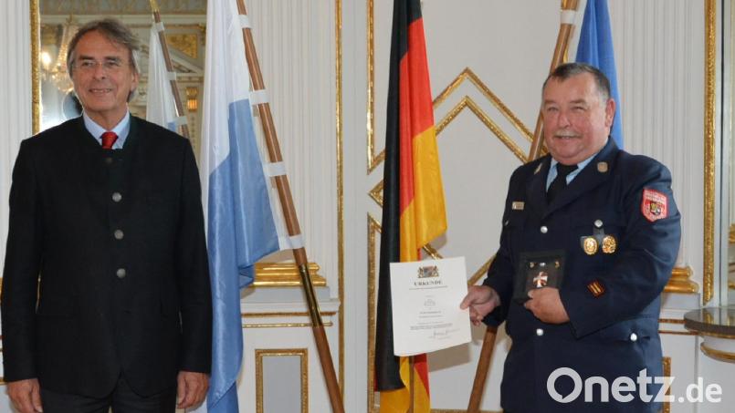 Regierungspräsident Axel Barthelt (links) überreichte Konrad Hoch (rechts) das Steckkreuz samt Urkunde. Bild: Regierung der Oberpfalz/exb