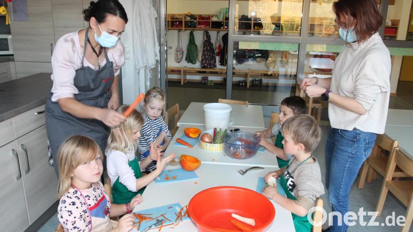 Irmgard Schaller-Fromm (links) zeigt den Kindern, was beim Schneiden oder Schnipseln zu beachten ist. Bild: pi