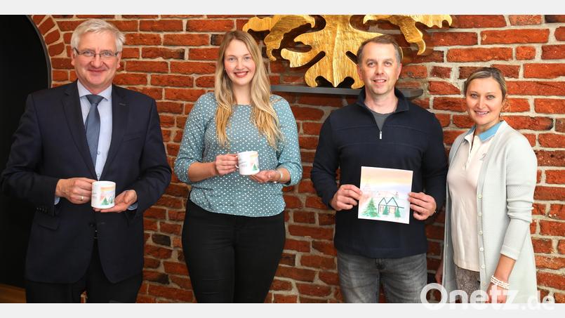 Joshua Dixon (Zweiter von rechts) ist der Künstler, der beim Malwettbewerb als Sieger hervorging und damit das Motiv zur diesjährigen &quot;Erbendorfer Weihnachtstasse&quot; stellt. Mit auf dem Bild Ehefrau Viktoria (rechts) sowie (von links) Bürgermeister Johannes Reger und Organisatorin Carolin Böckl. Bild: njn