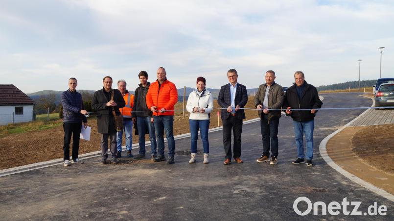 Bürgermeister Martin Birner (dritter von rechts) und seine Stellvertreterin Margit Reichl freuen sich über das Baugebiet mit zehn Parzellen und zerschneiden zusammen mit Vertretern des Stadtrats, der Firma Seebauer aus Girnitz und des Ingenieurbüros Weiß, Neunburg, das Band, um das Gebiet freizugeben. Bild: wel